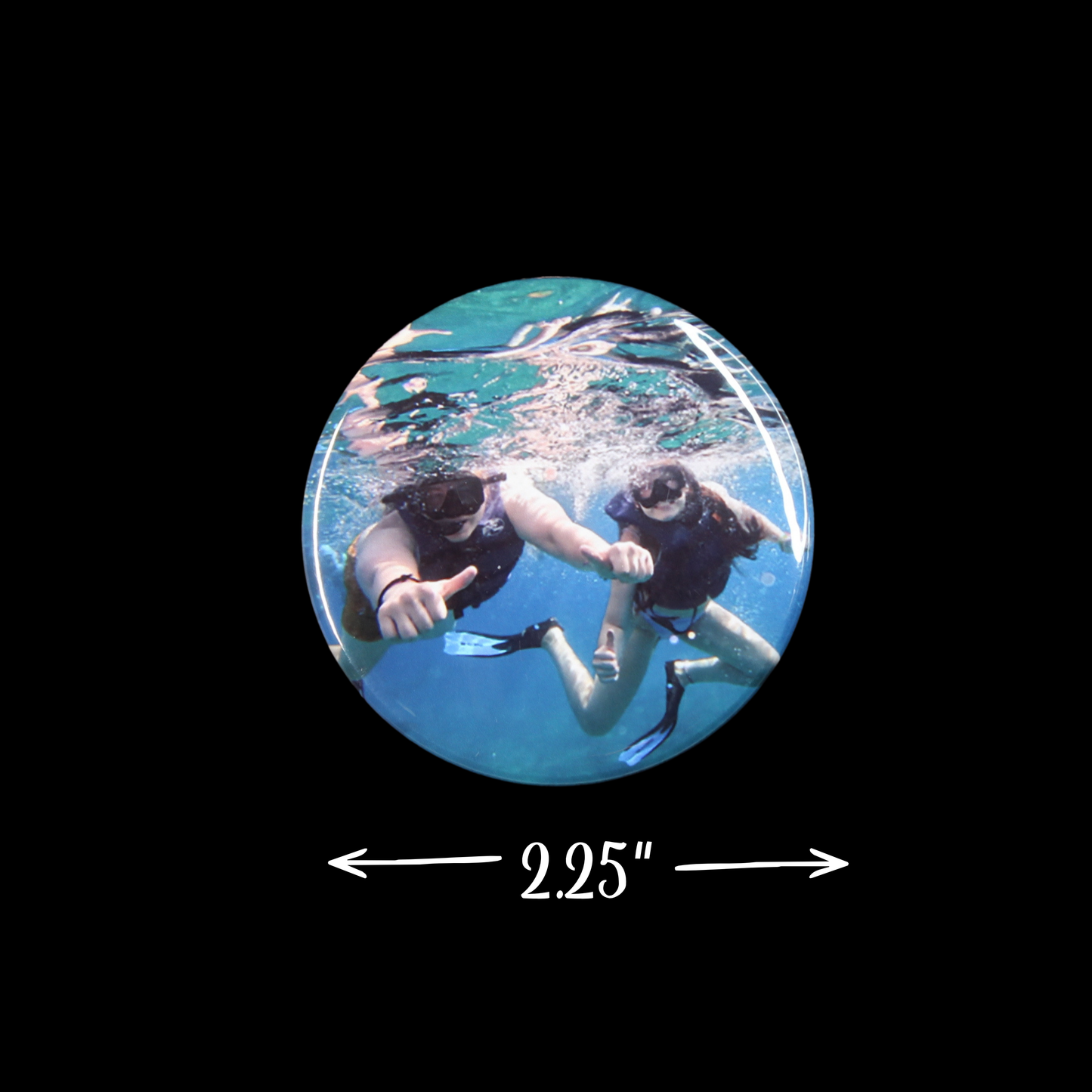 Two people underwater with a circular inset showing their size relative to 2.25 inches.