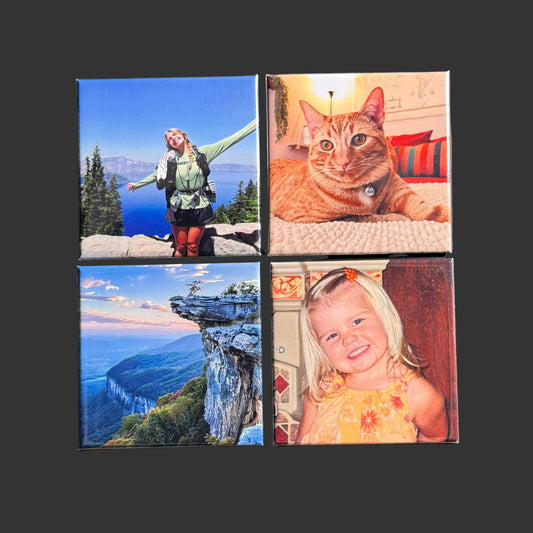 Four square magnets with different images on a black surface